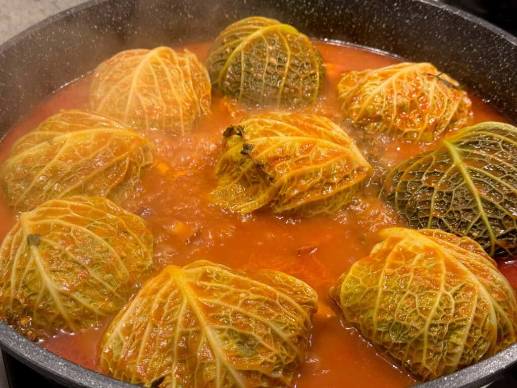 Choux farcis en cuisson dans une sauce tomate aux herbes au restaurant Gourmet & Glouton Chaudes-Aigues