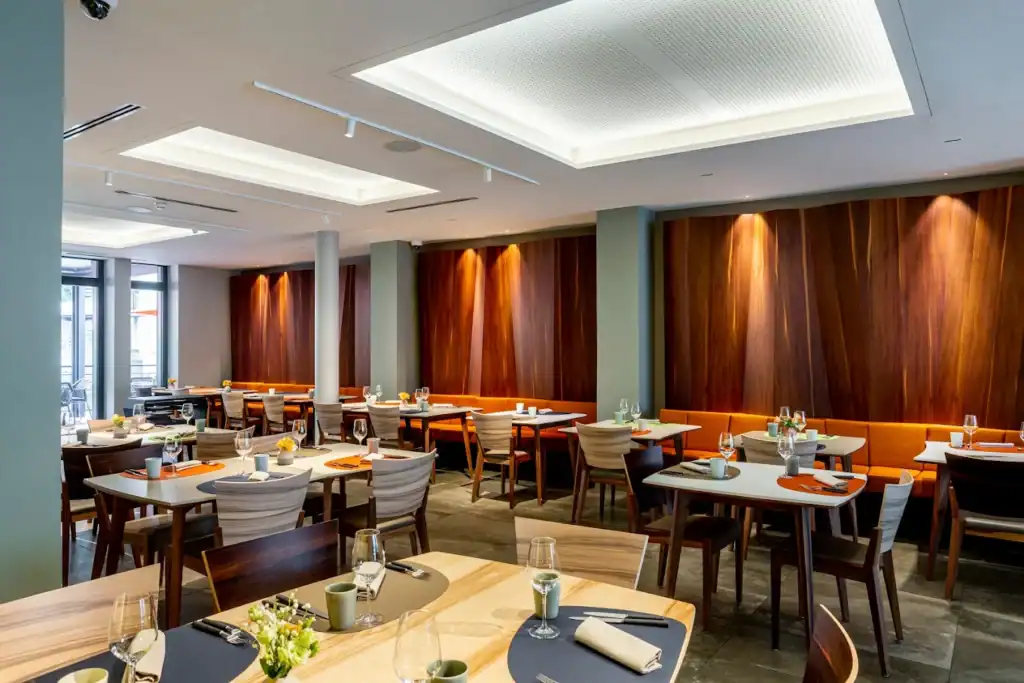 Salle de restaurant lumineuse avec tables prêtes pour les clients.