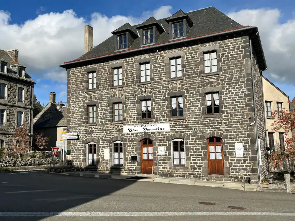 Façade de l’hôtel L’Annexe d’Aubrac en pierre, situé dans un village pittoresque.