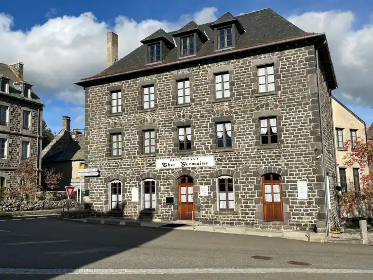 Façade de l’hôtel L’Annexe d’Aubrac en pierre, situé dans un village pittoresque.