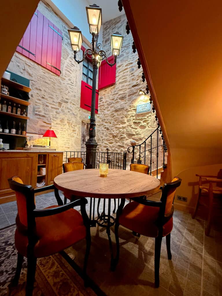 Intérieur du restaurant Gourmet & Glouton à Chaudes-Aigues avec réverbère de la place des Bougnats et ambiance bistrot auvergnat