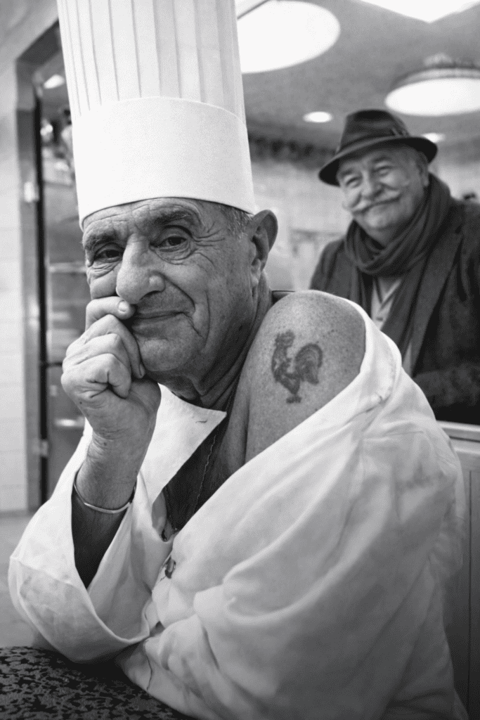 paul bocuse avec tatouage coq cuisine française ventru en arrière plan