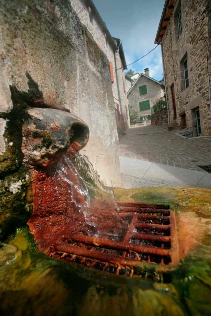 source d'eau chaude ferrugineuse dans une rue de Chaudes-Aigues
