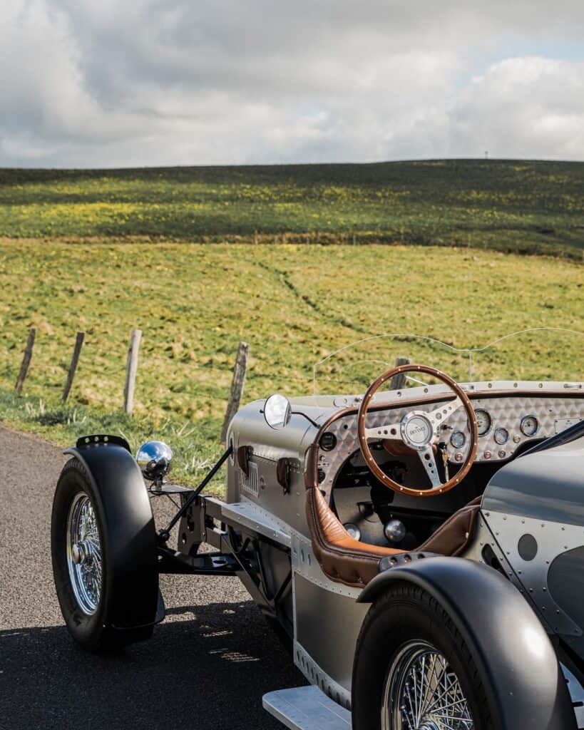 Voiture Devinci sur les routes du plateau de l’Aubrac avec paysage du Cantal et de la Lozère