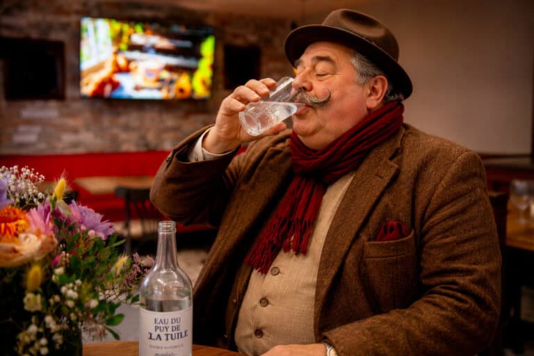 Le Ventru savoure un verre d'eau fraîche dans le restaurant Gourmet & Glouton à Chaudes-Aigues après une journée de fortes chaleurs.